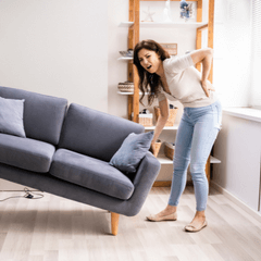 Woman Moving Sofa at Home